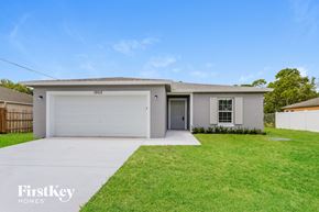 Port St. Lucie house for rent - a white house with a lawn and a garage door