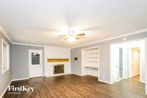 Indianapolis house for rent - a living room with a ceiling fan and a fireplace
