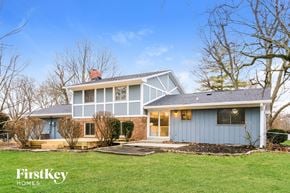 Indianapolis house for rent - a white house with a blue exterior and a green lawn