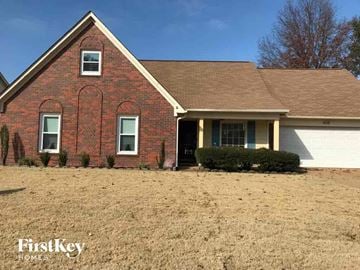 Memphis house for rent - a brick house with a grassy yard in front of it