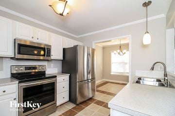 Clemmons house for rent - a kitchen with stainless steel appliances and white cabinets