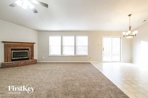 Avon house for rent - A spacious room with a fireplace and a rug on the floor.