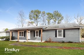 Lawrenceville house for rent - a blue house with a green lawn and trees