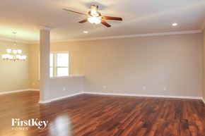 Gastonia house for rent - an empty living room with a ceiling fan and a window