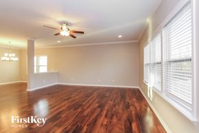 Gastonia house for rent - an empty living room with a ceiling fan and large windows