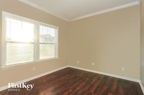 Gastonia house for rent - an empty room with wooden floors and two windows