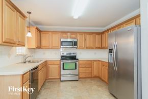 Winston Salem house for rent - a kitchen with wooden cabinets and stainless steel appliances