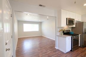 Sacramento house for rent - an empty kitchen and living room with a stove and microwave