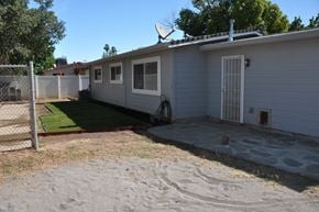 Sacramento house for rent - a white house with a driveway and a yard with grass
