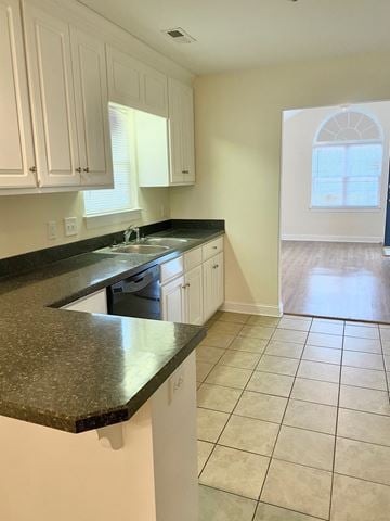 Nashville apartment for rent - A kitchen with white cabinets and a black countertop.