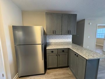 Rocky Mount apartment for rent - A kitchen with a stainless steel refrigerator and cabinets.
