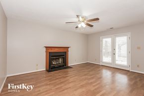 Charlotte house for rent - a living room with a fireplace and a ceiling fan