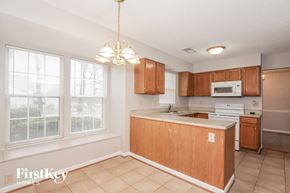 Charlotte house for rent - a kitchen with wood cabinets and a white counter top