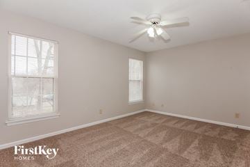 Charlotte house for rent - a spacious living room with carpet and a ceiling fan