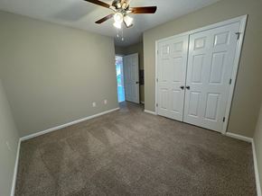 Nashville apartment for rent - an empty living room with carpet and a ceiling fan