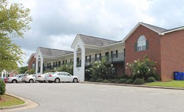 Nashville apartment for rent - A red brick building with a white entrance and cars parked in front.