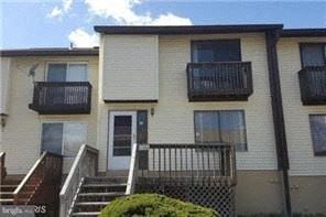 Laurel house for rent - A two-story apartment building with balconies and a fence in front.