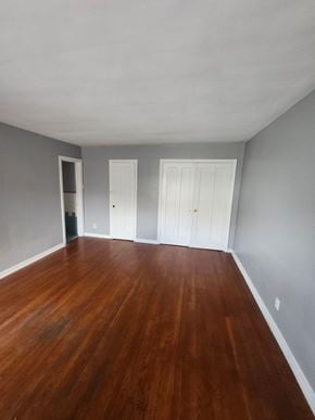 Cincinnati apartment for rent - A room with wooden floors and two white doors.