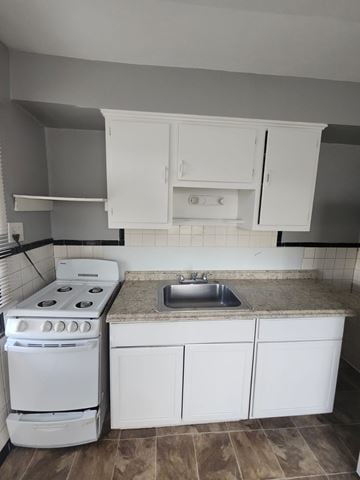 Cincinnati apartment for rent - A white kitchen with a stove, sink, and cabinets.