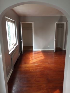Cincinnati apartment for rent - A room with wooden floors and white walls.