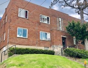 Cincinnati apartment for rent - A red brick building with a tree in front.