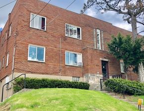 Cincinnati apartment for rent - A red brick building with a tree in front.