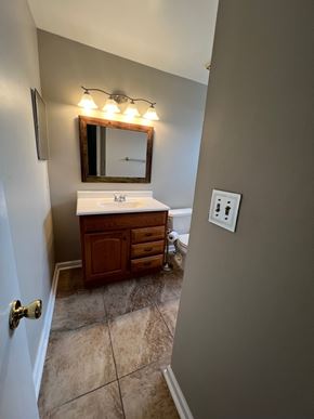 Laurel house for rent - A bathroom with a sink, mirror, and light fixture.