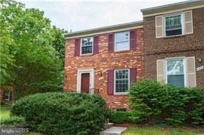 Laurel house for rent - A red brick house with green bushes in front.