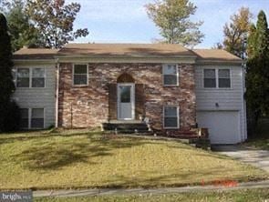 Fort Washington house for rent - A house with a white garage door and a brown brick exterior.