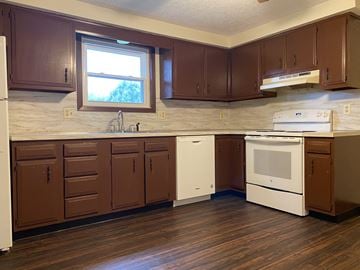 Massillion apartment for rent - A kitchen with brown cabinets and white appliances.