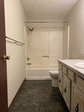 Massillion apartment for rent - A bathroom with a toilet, sink, and bathtub.