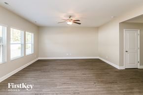 Charlotte house for rent - A spacious room with a ceiling fan and wooden flooring.