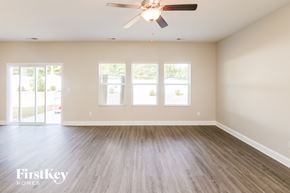 Charlotte house for rent - A spacious room with a ceiling fan and wooden flooring.