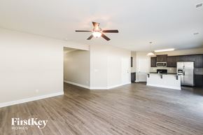 Charlotte house for rent - A spacious room with a ceiling fan and wooden flooring.