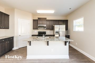 Charlotte house for rent - A kitchen with a granite countertop and a refrigerator.