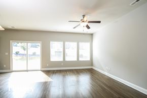 Charlotte house for rent - A room with a ceiling fan and sliding glass doors.