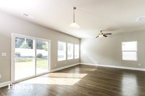 Charlotte house for rent - A spacious room with a ceiling fan and sliding glass doors.