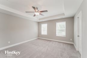 Charlotte house for rent - a bedroom with a ceiling fan and a carpeted floor