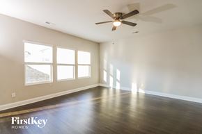 Charlotte house for rent - A spacious room with a ceiling fan and wooden flooring.
