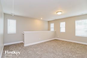Charlotte house for rent - A spacious room with a carpeted floor and three windows.