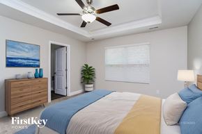 Charlotte house for rent - A bedroom with a bed, dresser, and a ceiling fan.