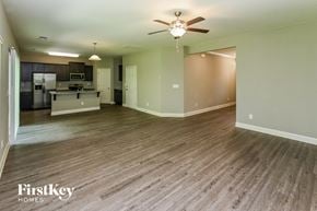 Charlotte house for rent - A spacious room with wood flooring and a ceiling fan.