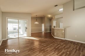 Riverview house for rent - an empty living room with wood flooring and a door to the kitchen