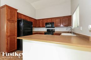 Buckeye house for rent - a kitchen with wooden cabinets and a black refrigerator