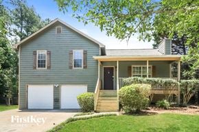 Douglasville house for rent - a blue house with two white garage doors