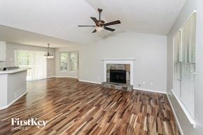 Douglasville house for rent - a living room with a fireplace and a ceiling fan