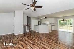 Douglasville house for rent - the living room and kitchen with wood flooring and a ceiling fan