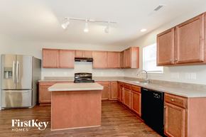 Winston Salem house for rent - a kitchen with wooden cabinets and stainless steel appliances and a counter top