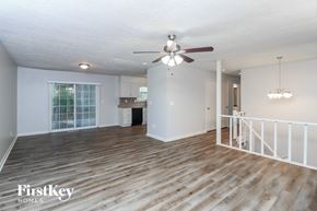 Douglasville house for rent - A spacious room with wooden flooring and a ceiling fan.