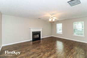 Buford house for rent - the living room with wood flooring and a fireplace